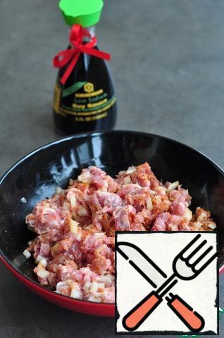 Grind pork into minced meat, add finely chopped onion, spices, soy sauce. Mix well the minced meat until smooth.