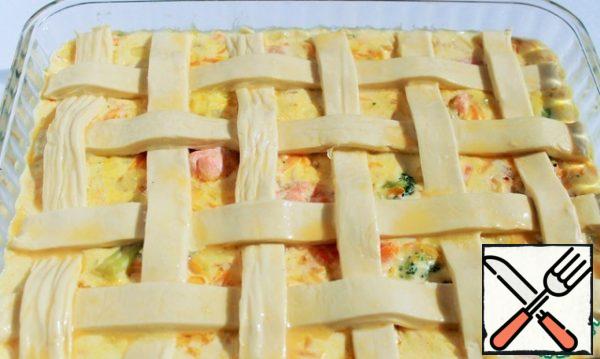 Lay out strips of dough on top in the form of a weave. Beat the egg and use a brush to lubricate the dough strips.
Bake for 30-35 minutes at a temperature of 200 g. until the dough is golden brown. Chill for 5 minutes and serve.