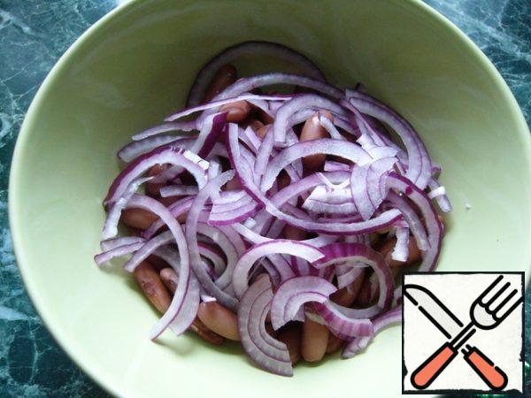Put the cooled beans in a bowl.
Add red onions to the beans, cut into thin half-rings.