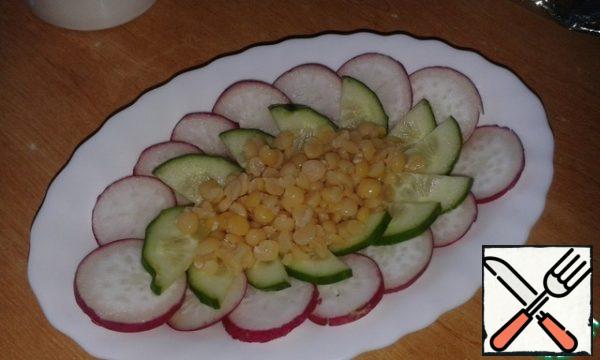 Then you can experiment by adding eggs, cheese, pieces of ham to the dish, but I decided to make it as easy and simple as possible. In a circle to lay the radishes, then the cucumbers, and in the center of boiled peas. Salt to taste.