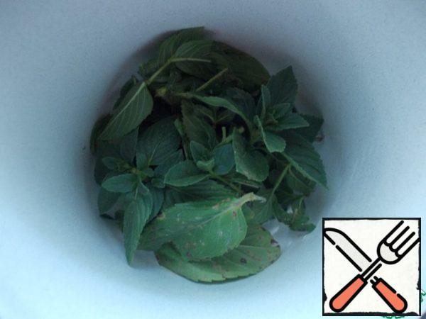 Mint leaves are sent to a mortar.
