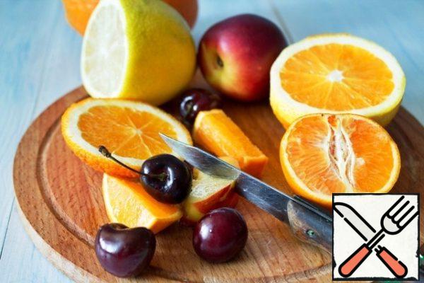 Wash and slice the fruit, remove the seeds from the cherries. Squeeze the juice from one orange and half a lemon. Cut the yellow zest from the lemon.
