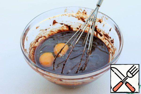 Sift flour with salt, baking soda and baking powder.
In the cooled chocolate mass add eggs and whites egg, mix with a whisk.