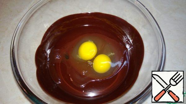 Add eggs to the chocolate mass.
