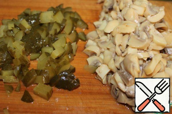 Chop the mushrooms and pickles.

