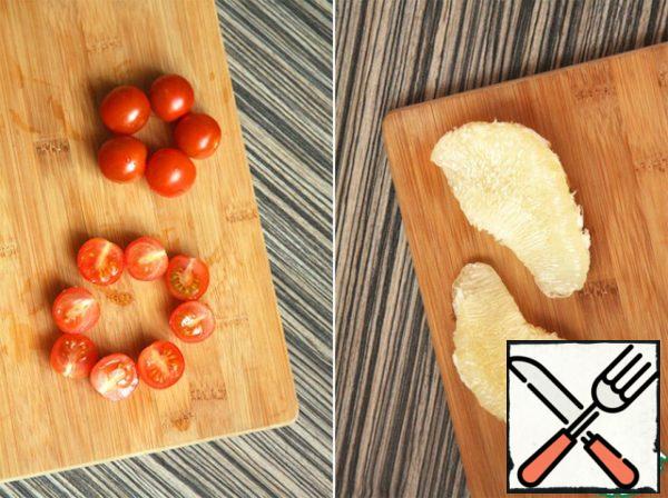 Wash cherry tomatoes and cut into halves.
Separate the pomelo from the skin and films.