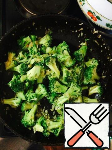 To the onions add the broccoli, adjust the flame on the stove on a small level. Fry for 7 minutes. While cooking, stir the ingredients so it doesn't burn.
