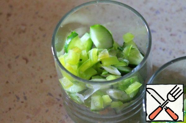 Next, add the cucumber cut into half rings, bell pepper cubes, green onions.