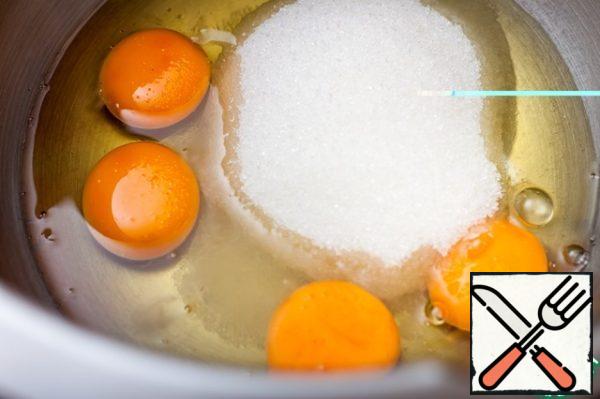 Beat eggs with sugar in a lush dense foam.