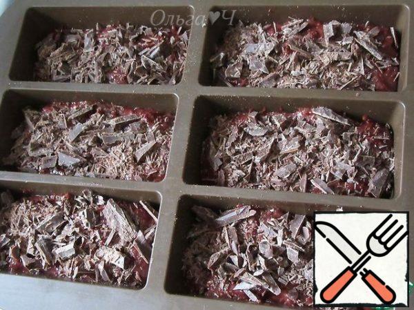 Spread the dough into molds, sprinkle with crushed chocolate.
