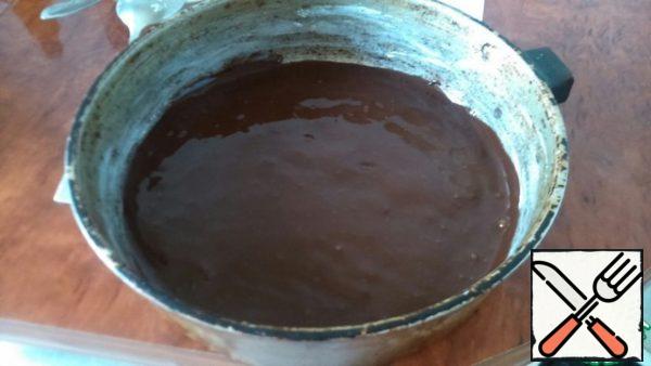 Grease the bottom and edges of the mold with a piece of butter, pour out a third of the chocolate dough, smooth it out.
