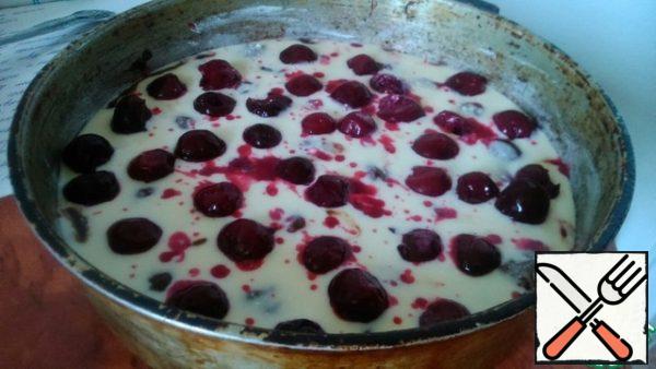 Pour the remaining curd mass on top and evenly distribute the cherries in the form.
