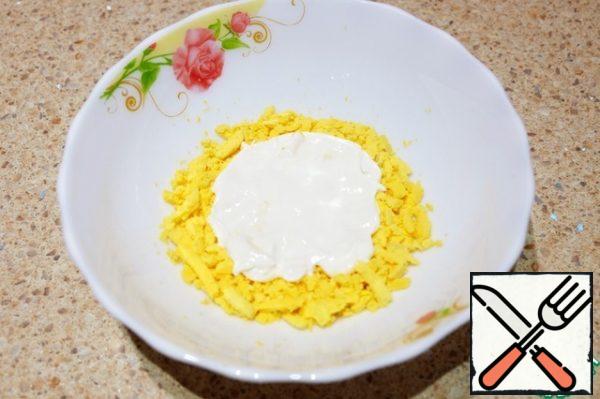 In a bowl place a layer of yolks, add a thin layer of sour cream.