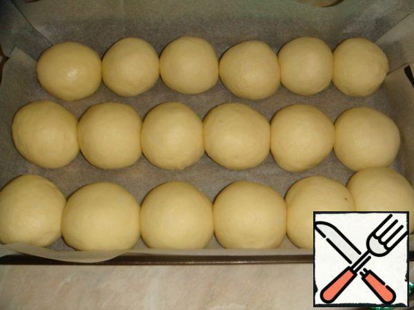 The approached dough is divided into 18 pieces.
Put them on a baking sheet lined with parchment and leave for another 1 hour.
For 15-20 minutes before baking, preheat the oven to 200 * C.
