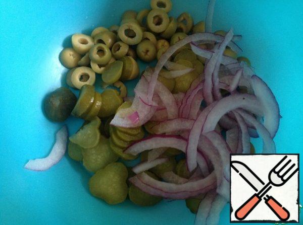 Put the beans to cook in salted water. After cutting off the tails of the beans. Cut olives and cucumbers into rings, onions into half rings.
