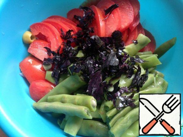 Put the finished beans in a colander and rinse with cold water. Cut the beans large enough. Cut the tomato into slices, chop the basil (leaves).
