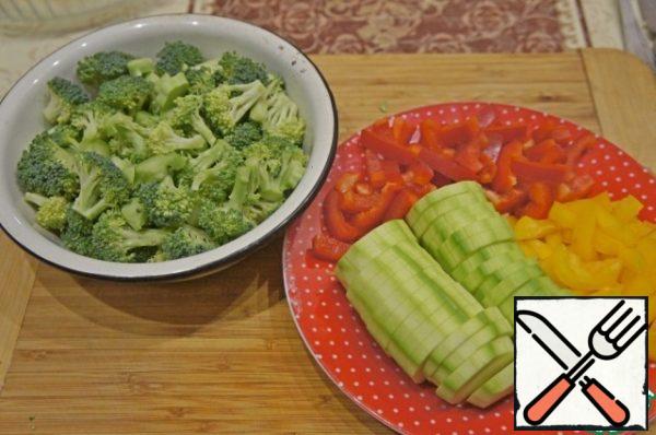 Pepper peel and cut into strips, zucchini – thin slices.
Broccoli disassemble into small inflorescences.
Finely chop the greens.