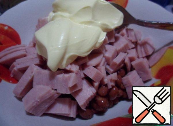 Add the ham to the beans, add the mayonnaise, it is better to take tasty (I have olive), mix well. No salt.