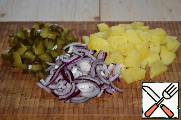 Pre-boiled potatoes cut into cubes, do not grind. Cucumbers cut into, too, not very chopped. Onions-half rings. Put the vegetables in a salad bowl.