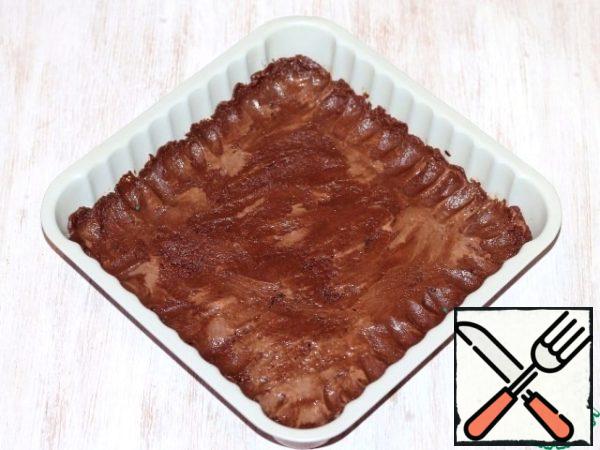 Take the form (21*21) for baking. Cover with baking paper (grease with oil) or silicone Mat (do not grease). Spread 1/2 of the chocolate dough in the mold.