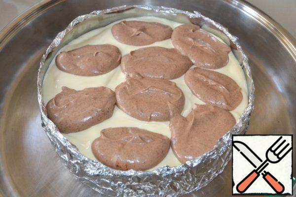 Melt 60 g of chocolate, mix with the rest of the curd mixture.
Spoon the chocolate part over the white part and make the stains with a knife, gently mixing both mixtures.
