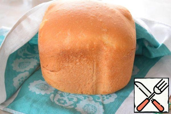 We pull the bread out of the bucket, wrap it in a towel and leave to cool.