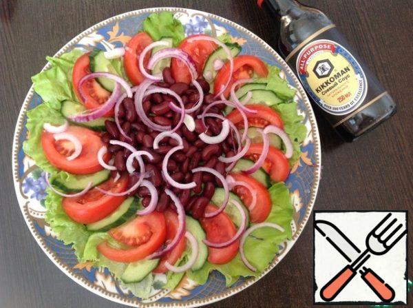 Drain the liquid from the canned beans, if necessary, rinse with cold boiled water. Put it in the middle. Peel the red onion and cut it into thin slices. Put it on top.