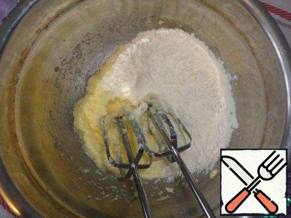 Add the sifted flour with baking powder to the whipped mass and beat it again with a mixer.
