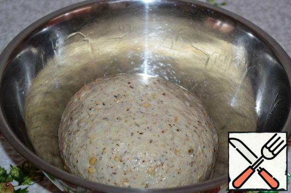 Put the dough in a Cup, greased with vegetable oil, tighten with cling film and put in a warm place for an hour.