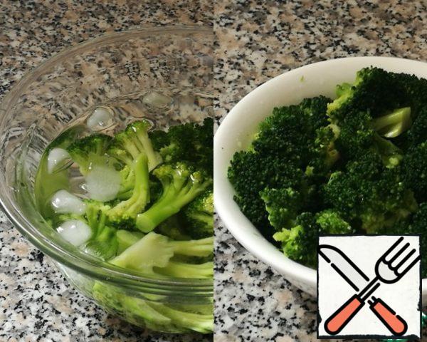 Broccoli can be fresh or frozen, it doesn't matter, the procedure is the same.
Divide the broccoli into small inflorescences, place in a pot of boiling water, cook for 4 minutes. Cover to cover, the sprouts will retain their bright green color. Then put the cabbage for 5 minutes in a bowl of cold ice water (I add ice cubes), then drain in a colander and drain off the water.
Look how bright and juicy the broccoli is.