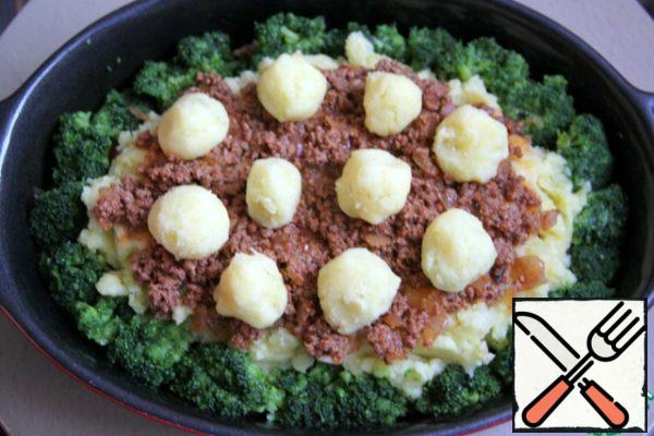 Put another 1/3 of the minced meat on top. From the delayed mashed potatoes, make balls the size of a walnut and put them in the center.