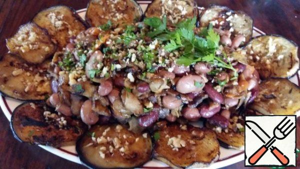 Slices of fried eggplant to put on the edges of the dish, sprinkle them with a second clove of garlic and chopped walnuts. In the center of the positioning of the salad, garnish with greens.