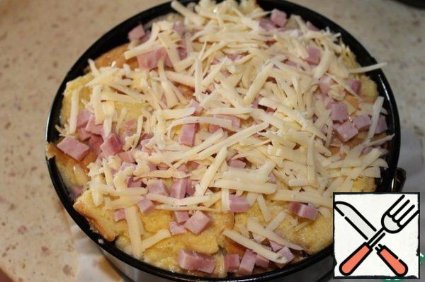 Cover the form with parchment, lubricate 1 tablespoon of vegetable oil, put the contents of the package, tamp it with your hand. Sprinkle the remaining cheese and diced ham on top. Bake in a preheated 190 degree oven for 20-30 minutes, until browned.
