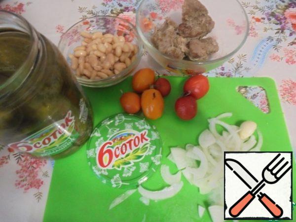 Prepare the ingredients for the salad.
With beans drain the liquid, wash and dry the vegetables.
Onions clean and cut into half rings.