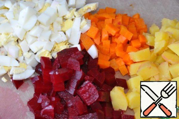 Cook carrots, beets, potatoes and eggs. Clean and cut into cubes.