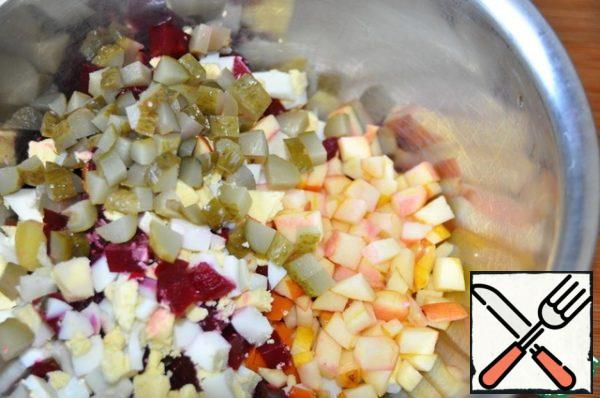 Add the sliced cucumbers to the vegetables and eggs. Add the diced apple.
