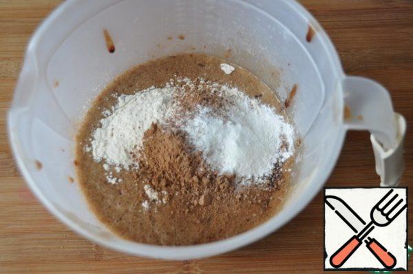 Add flour, cocoa (1 tablespoon) and baking powder, mix with a spatula.
