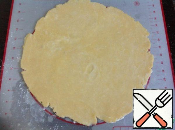 Roll the dough on a lightly floured surface using a polyethylene film with a thickness of 0.5-0.7 cm In this case, the dough does not stick to the rolling pin.