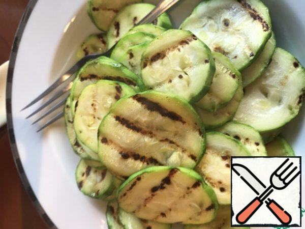 Clean the young zucchini, cut into slices, salt and fry on the grill pan.