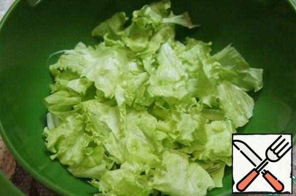 Cut cucumber into half rings, tomatoes into slices, pepper into strips.
Lay out a flat dish with lettuce leaves. Transfer the remaining salad by hand into small pieces in a deep bowl.

