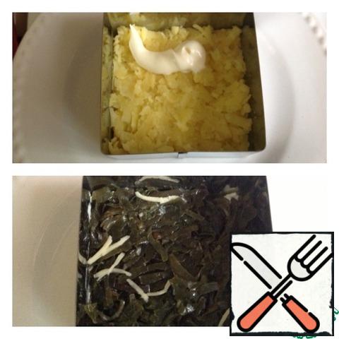 Peel potatoes and grate on a large grater, grease with mayonnaise. With cabbage drain the excess liquid and put on top of the potatoes.