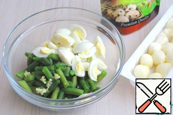 In a bowl add sliced cheese, quail eggs, string beans, add the garlic passed through the garlic press. If necessary, add salt.