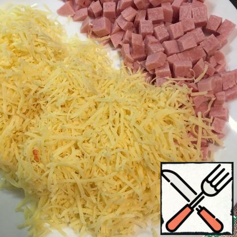 While the dough is suitable we prepare the filling, sausages cut into small cubes, cheese three on a fine grater.