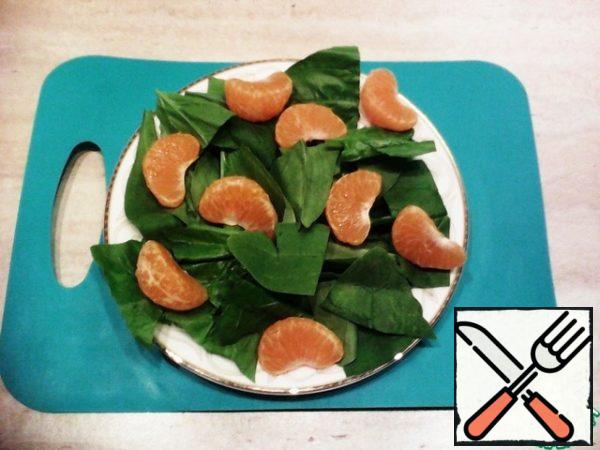 Spinach wash, dry. Hard petioles cut, if the leaves are large cut into 2-3 large parts. Put on a serving plate.
Mandarin (I took one) to clean, disassemble into slices, remove white streaks. Spread the slices on the spinach.