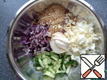 Boil eggs. Cut the eggs finely, cucumber into strips, red onion half rings. The cabbage and add all the ingredients.