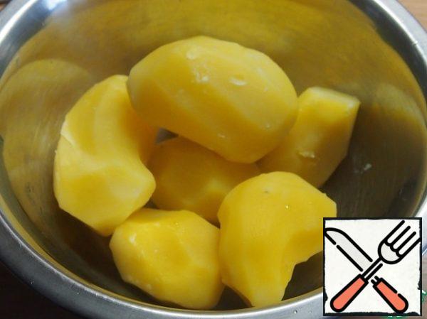 Peel the potatoes and boil them whole in salted water until tender, but do not boil them.
