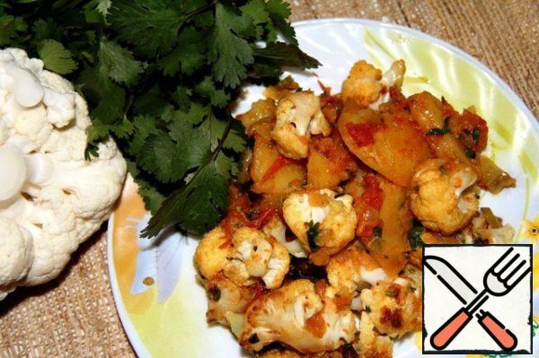 Put potatoes and cauliflower in a frying pan with sauce. Salt to taste and add cilantro (rinse, dry and finely chop). Simmer, stirring occasionally, for another 5 minutes.