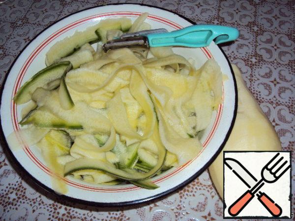 Wash the young zucchini, remove one strip with a vegetable peeler and use it to chop the zucchini along the entire length, grabbing a thin part of the skin. So, chop the zucchini whole without removing the seeds.

