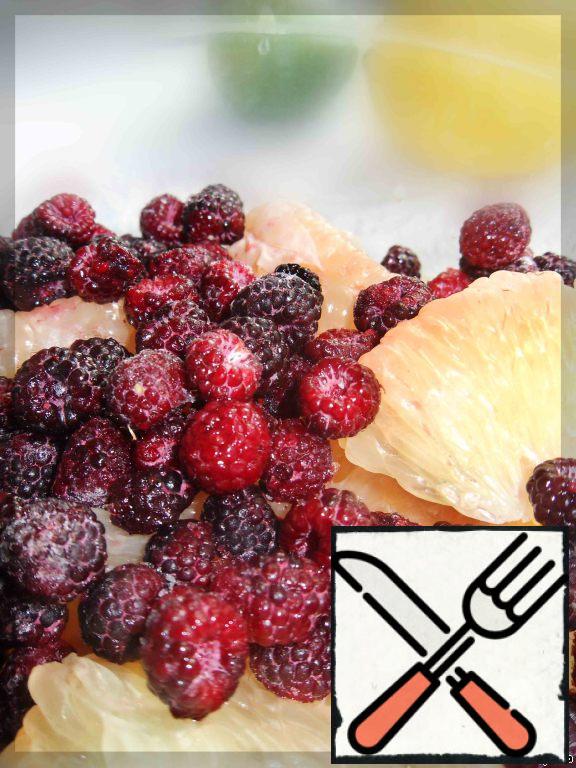 The pulp of grapefruit mix together with blackberries, powdered sugar and lemon.