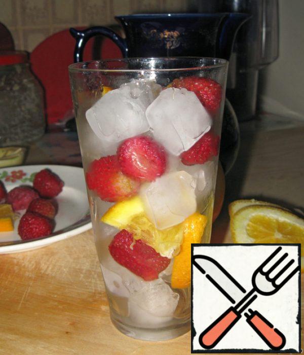 In high glasses put ice cubes, shifting them with frozen strawberries (it will also serve as an ice cooler) and pieces of orange. Pour into glasses brewed tea and enjoy the fruit coolness!